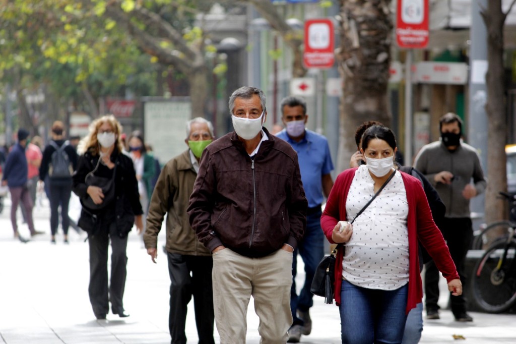personas caminando por la calle usando mascarillas debido a la pandemia por coronavirus, una de las zoonosis estudiadas por la Medicina Veterinaria. Fotografía de Alejandra Fuenzalida.
